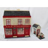 A scratch built dolls house in the form of a shop with a tiled roof,