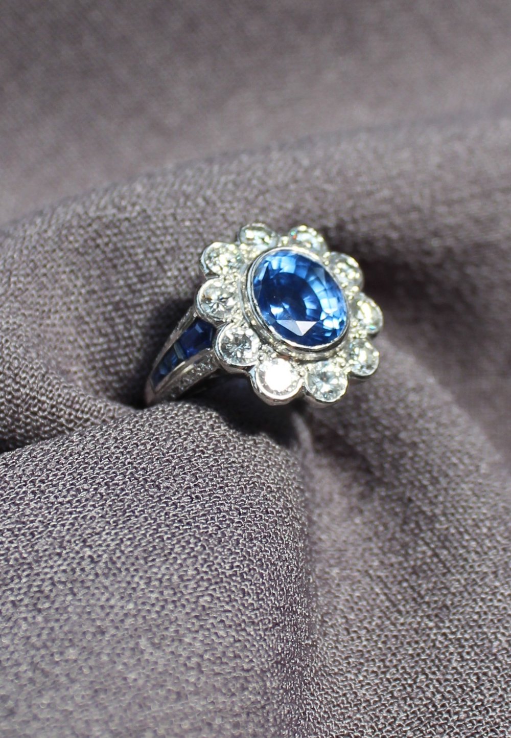 A sapphire and diamond cluster ring, the central sapphire measuring approximately 10mm by 8mm, - Image 4 of 7