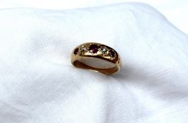 A yellow metal gypsy ring set with three rubies and two old cut diamonds, marked 18ct,