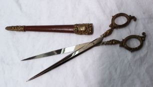 A pair of German long scissors, the handles with gilt decorated leaves, the blades 17cm long,