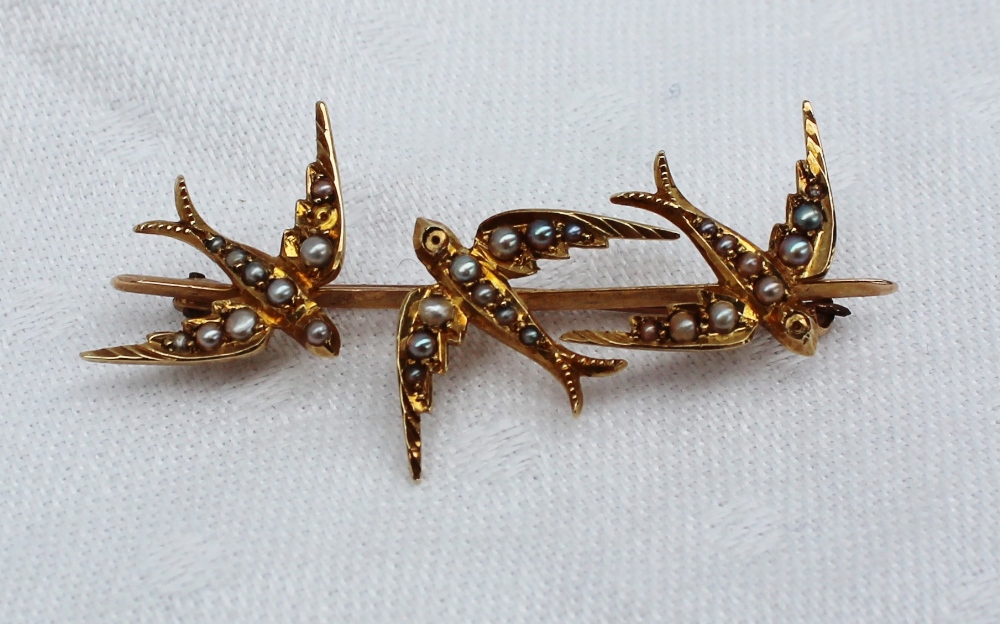 A yellow metal bar brooch in the form of three swallows, set with seed pearls, marked 15c, - Image 2 of 3