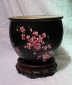 A Carlton ware jardiniere, decorated with prunus blossom to a black ground,