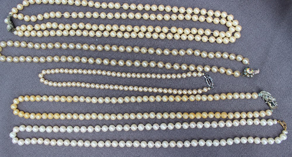 A pearl necklace set with eighty regular individually knotted pearls to a yellow metal clasp,