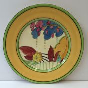 A Clarice Cliff plate in the moonlight pattern, with a green and yellow border, painted to the