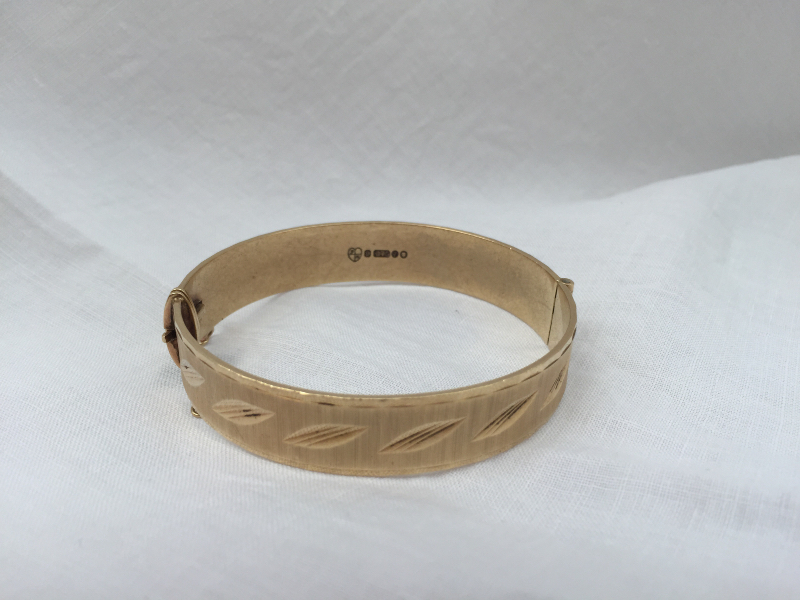 A 9ct yellow gold hinged bangle, with line and leaf decoration, - Image 2 of 3