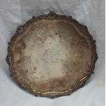 An Elizabeth II  silver salver with a shell and leaf border, on three leaf cast feet,