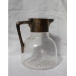 An Edwardian silver topped claret jug, with a plain top and angular handle above a bulbous glass