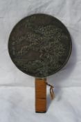 A Japanese bronze hand mirror of paddle form, cast with cranes, turtle, text and a blossom tree, the