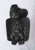 An Argillite plaque, depicting figure heads within an eagle, inscribed Thorn, Canada on the reverse,