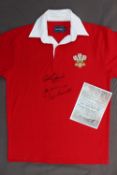 A replica Welsh rugby shirt signed by Gareth Edwards, JPR Williams and Phil Bennett,