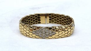 An 18ct yellow gold and diamond set bracelet of snake skin effect,