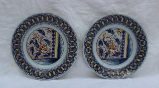 A pair of 19th century tin glazed earthenware plates, decorated with leaves and flower heads, the