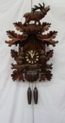 A modern Black Forest Cuckoo clock, with a roaring stag and leaf surmount,