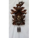 A modern Black Forest Cuckoo clock, with a roaring stag and leaf surmount,