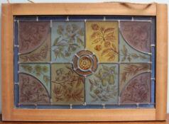 A Stained glass panel with coloured leaded glass panels painted with flowers, fruit and leaves,