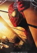 A poster for the Spiderman movie  depicting the head of spiderman with the World Trade Centre