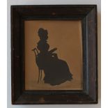 Auguste Edouart (1789-1861) 
A Silhouette of a Seated Lady sewing 
Cut paper 
Stamped and dated