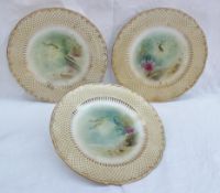 A set of three Minton porcelain plates painted with fish, seaweed and the seabed, initialled A.H.