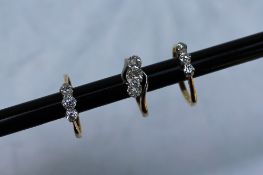 A three stone diamond ring set with graduated old cut diamonds to a white metal claw setting and a