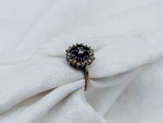 A sapphire and diamond dress ring, set with a central round brilliant cut diamond approximately 0.
