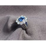 A sapphire and diamond cluster ring, the central sapphire measuring approximately 10mm by 8mm,