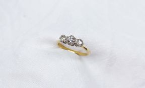 A three stone diamond ring set with old cut graduating diamonds to a white metal setting on a