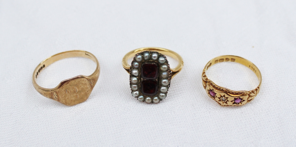 A ruby and diamond ring set with two rubies either side of a diamond in an 18ct yellow gold setting
