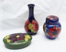 A Moorcroft pottery Hibiscus pattern vase, tube lined decorated with flowers to a royal blue ground,