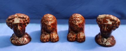 A pair of 19th century treacle glaze pottery rests in the form of a lion,