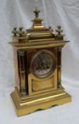 A 19th century brass mantle clock, with a domed top and flame finials,
