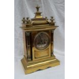 A 19th century brass mantle clock, with a domed top and flame finials,