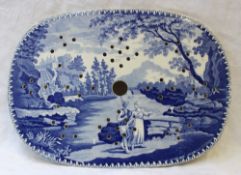 A 19th century blue and white pottery strainer plate, transfer decorated with a fisherman and a