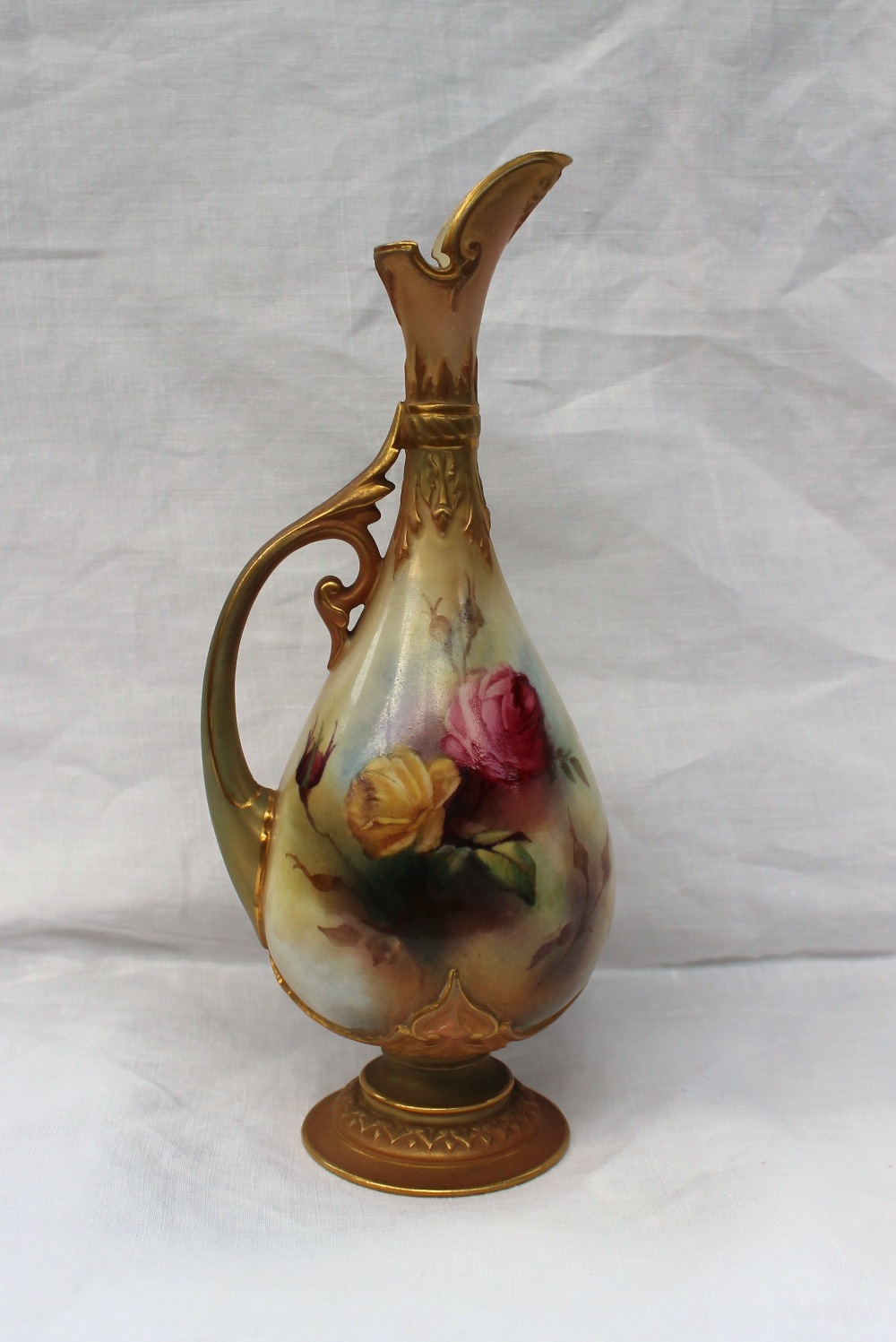 A Royal Worcester porcelain jug, painted with roses and leaves to a blush ivory ground, with moulded