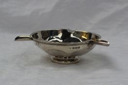A George VI silver ashtray of circular form with a panelled body on a spreading foot, Birmingham,