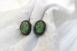 A pair of carved jade and enamel earrings in a white metal mount together with other earrings,