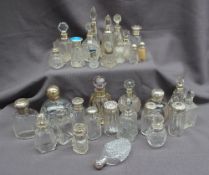 A large collection of silver and electroplated topped and glass scent bottles