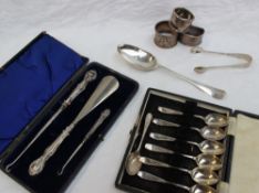 A George III silver table spoon, together with cased tea spoons, silver sugar nips and napkin rings,