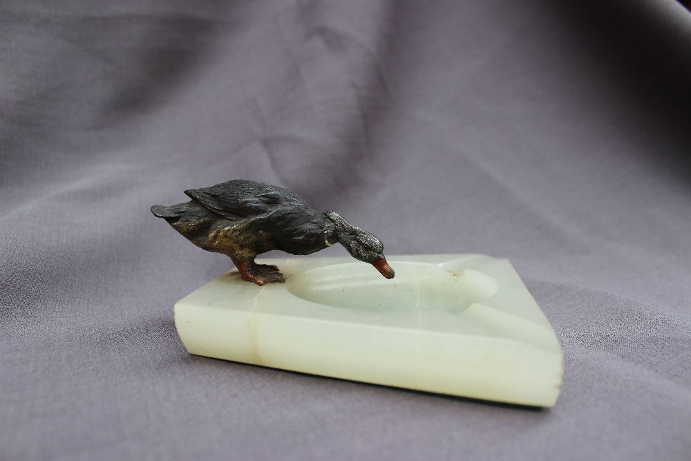 A cold painted spelter model of a drinking duck, standing on the edge of an onyx ashtray, - Image 2 of 4