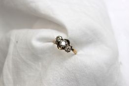 A three stone diamond ring set with three old cut diamonds to a white metal claw setting and yellow