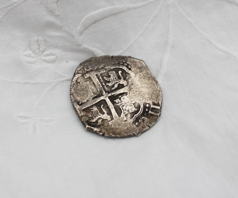 A white metal eight reale coin,