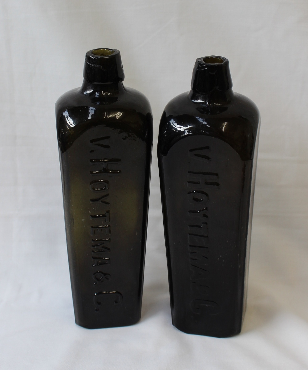 A pair of Hoytema & C green glass gin bottles on square tapering form,