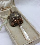 A continental white and gilt metal baby's rattle, of globe form, with a pointed whistle,