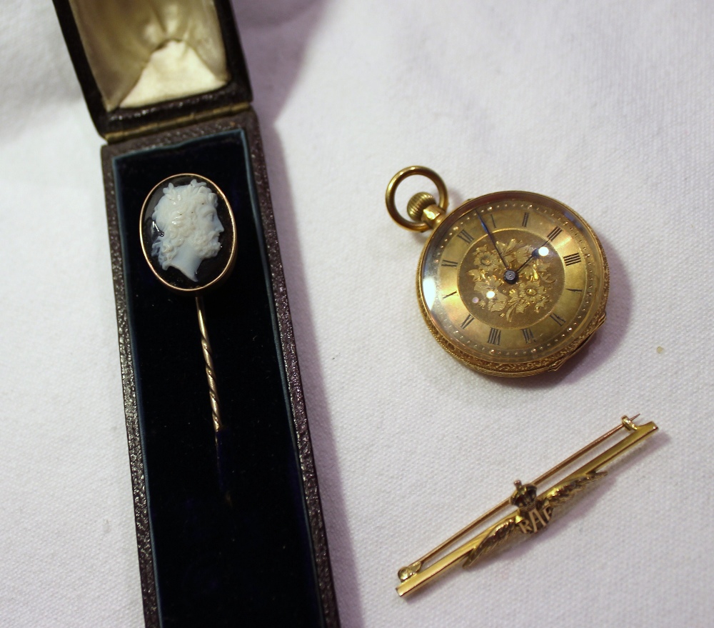 A hardstone cameo stick pin depicting a Romanesque figure head together with a yellow metal fob