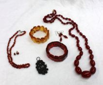 An amber bead necklace and matching earrings, together with a red bead necklace and two bracelets,