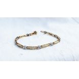 A tennis bracelet set with round brilliant cut diamonds to a yellow metal setting marked 14k