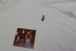 A white polo neck jumper, embroidered with a silver fern, gifted to the vendor by Brian Williams,