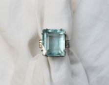 An Aquamarine and diamond dress ring the rectangular faceted aquamarine measuring 18mm x 15mm x 11mm