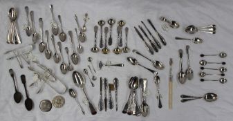 A collection of silver sugar nips together with silver tea spoons etc,