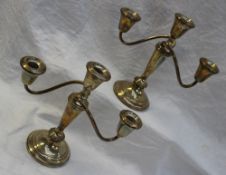 A pair of white metal two branch candelabra with scrolling arms ,
