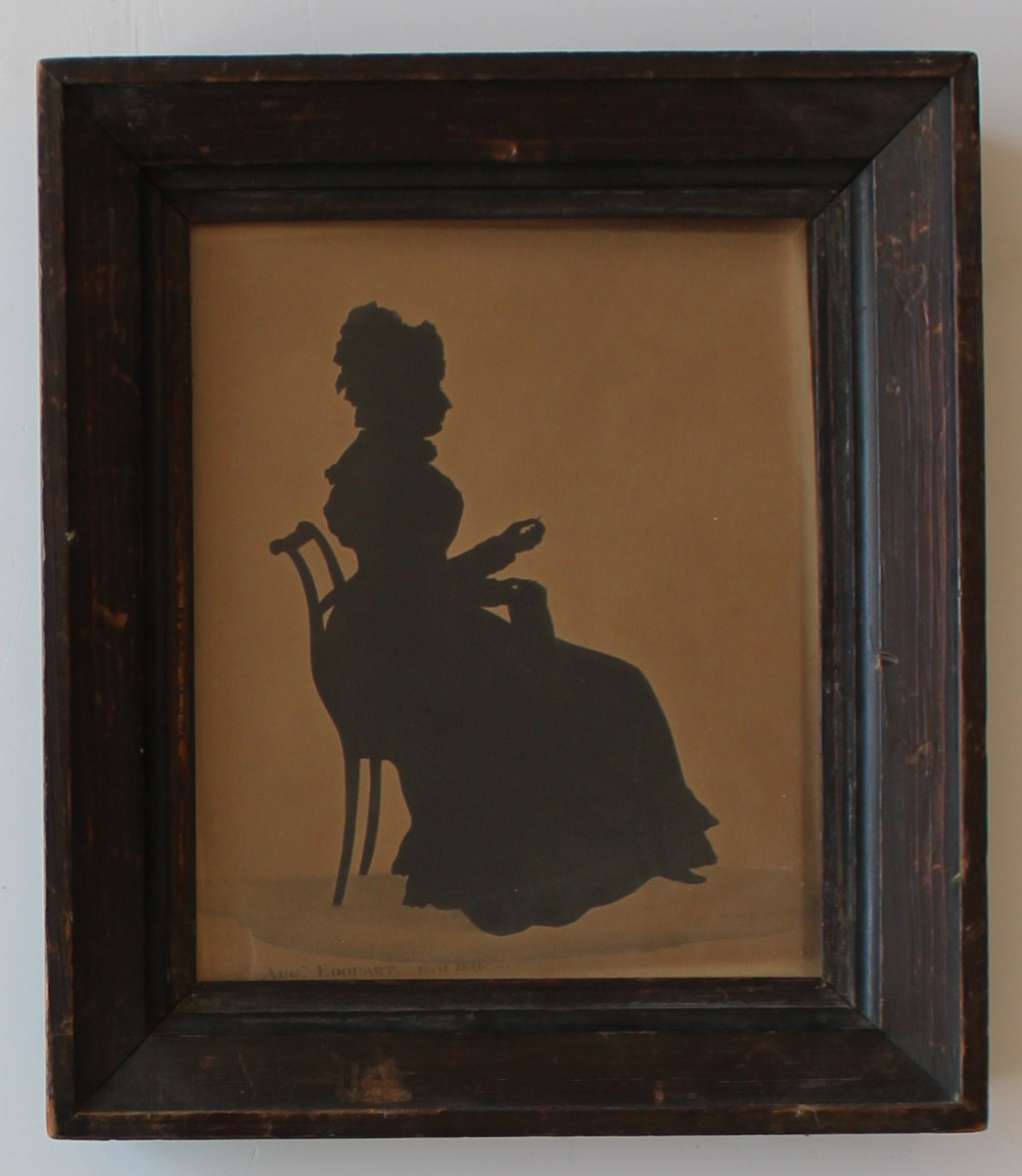 Auguste Edouart (1789-1861) 
A Silhouette of a Seated lady sewing 
Cut paper 
Stamped and dated